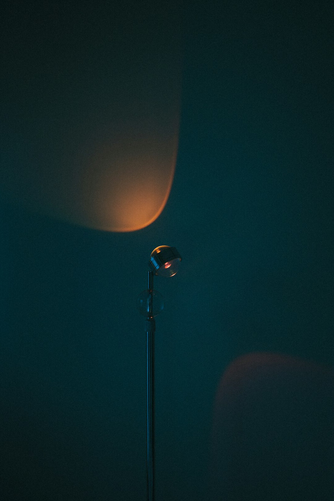 Microphone on a stand in a dim recording studio