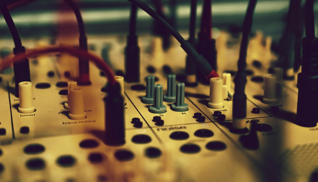 Close-up of audio mixing console faders and knobs